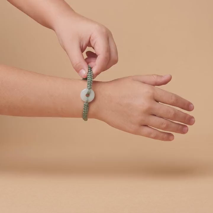 The Jadéa bracelet on a child's wrist, the jade lighting up